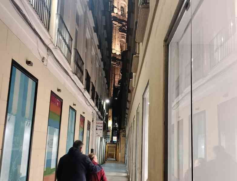 Deux personnes marchant dans un espace étroit bordé de bâtiments, photo gratuite