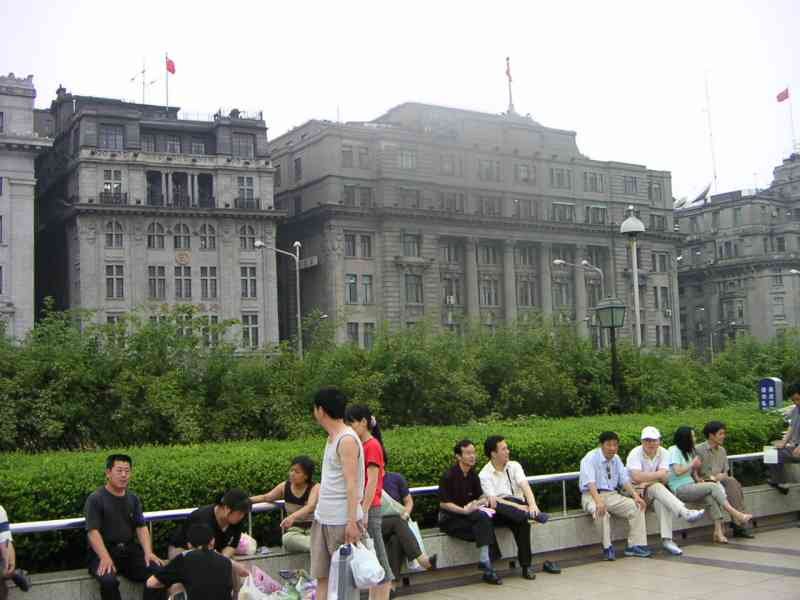Des personnes assises devant le batiment Bund Riverside, patrimoine colonial européen, monument du centre de la ville de Shanghai Chine, Asie photo gratuite