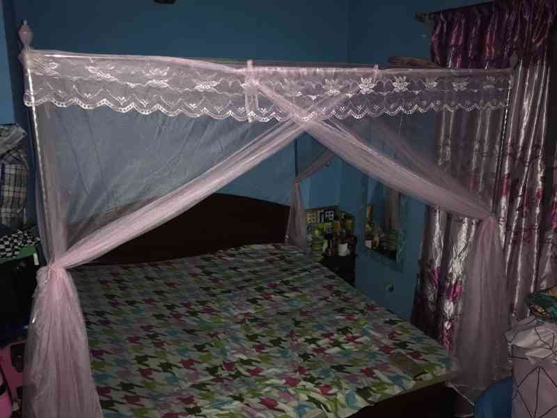 Un lit protégé par une moustiquaire rose photo gratuite