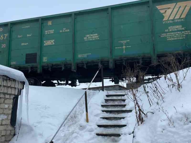 Passage d'un train de marchandise vert sur des rails enneigés photo gratuite