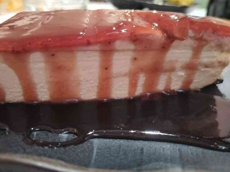Une part de gâteau, nappée de sauce aux fraises, photo gratuite
