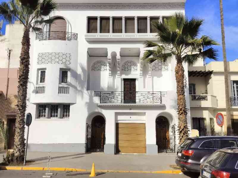 Façade d'un bâtiment blanc, en étage, à quelques mètres du goudron dans la ville de Casablanca au Maroc photo gratuite