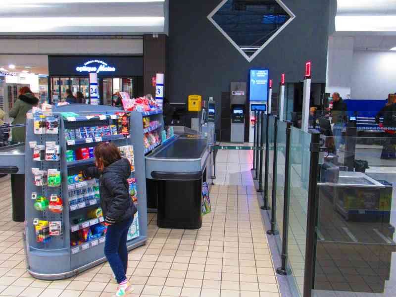 Jeune fille devant le rayon bonbons d'un supermarché photo gratuite