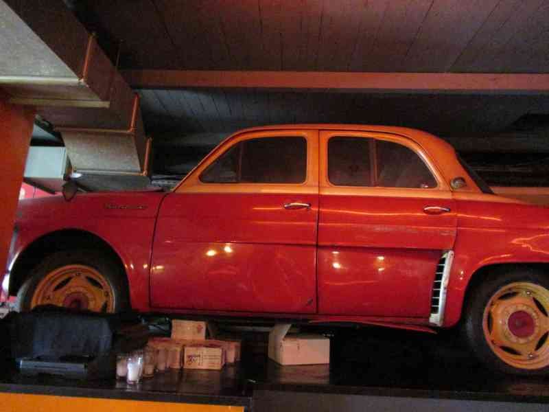 Voiture de marque Renault Dauphine rouge dans un garage