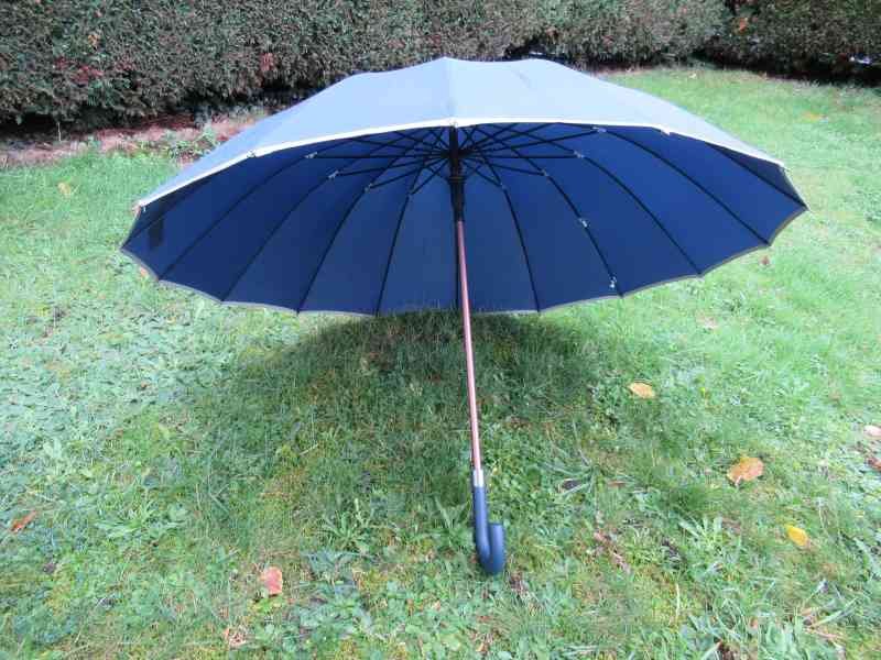 Open blue umbrella on a lawn
