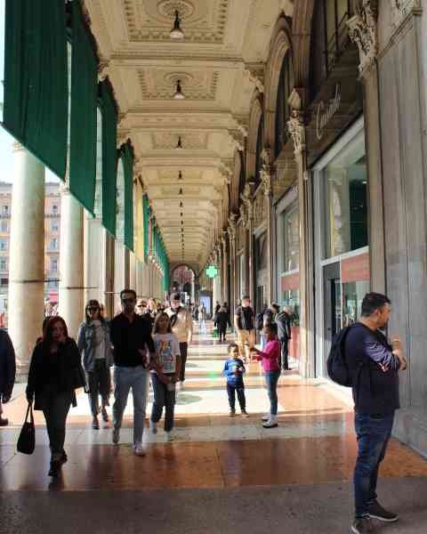 Quelques personnes dans le couloir de la galerie Vittorio Emanuele II, un monument emblématique de Milan, en Italie, photo gratuite