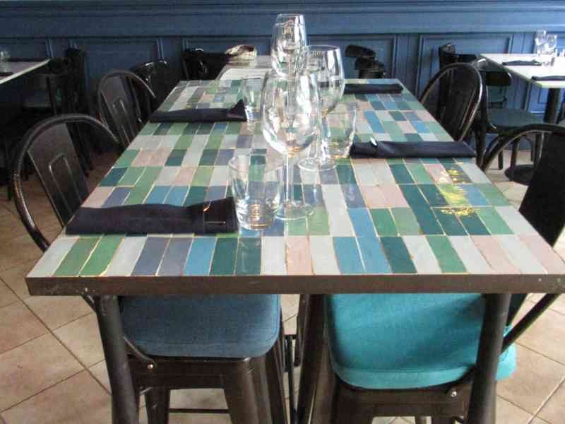 Intérieur d'un restaurant avec des tables carrées en mosaïques