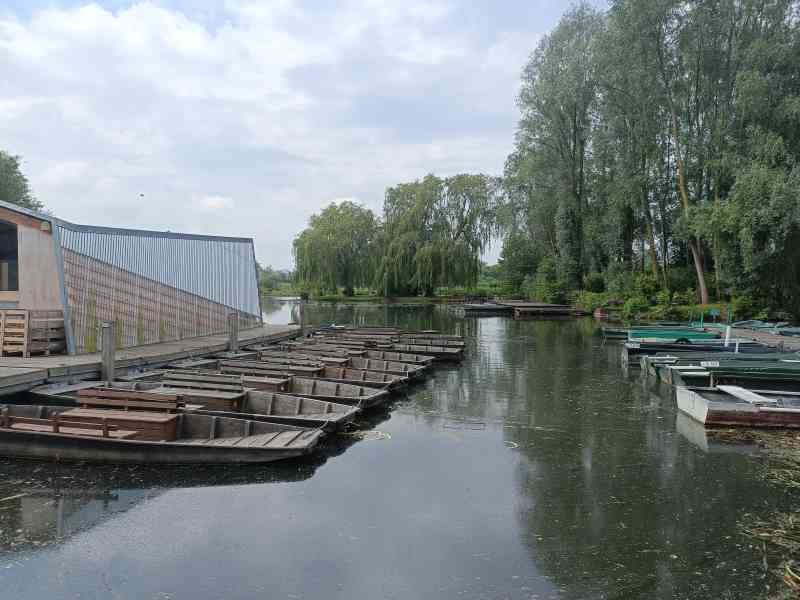 Des bateaux traditionnels, des barques à fond plat, amarrés le long d'un quai en bois, photo gratuite