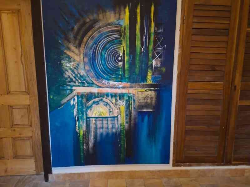Peinture acrylique abstraite accrochée sur un mur entre une porte en bois, photo gratuite