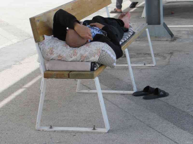 Person lying on a public bench