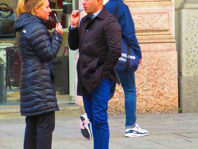Two people smoking and talking in the street free photo
