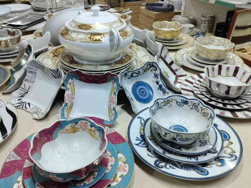 Des assiettes, des bols et une théière, exposés sur une table dans un rayon de magasin, photo gratuite