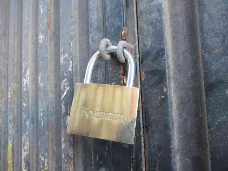 A locked Bossram padlock, attached to a container door, free photo
