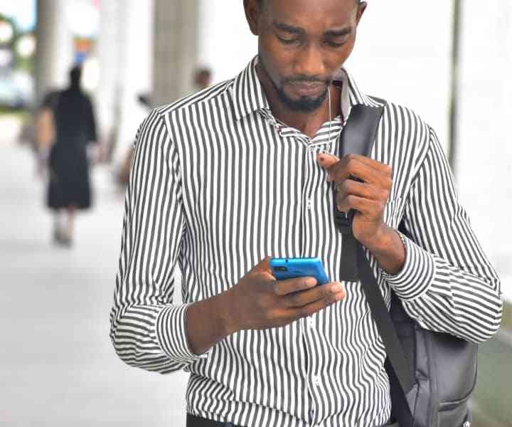 Un homme en pleine marche, absorbé par son téléphone photo gratuite
