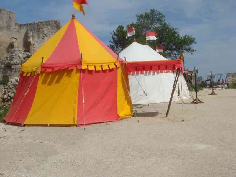 Deux tentes situées sur une surface en terre battue, avec un mur de pierre en ruine en arrière-plan photo gratuite - Zwei Zelte auf einer unbefestigten Fläche, mit einer zerstörten Steinmauer im Hintergrund, kostenloses Foto