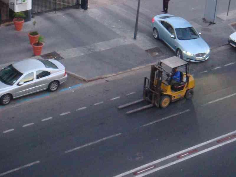 Un chariot élévateur en pleine circulation urbain photo gratuite