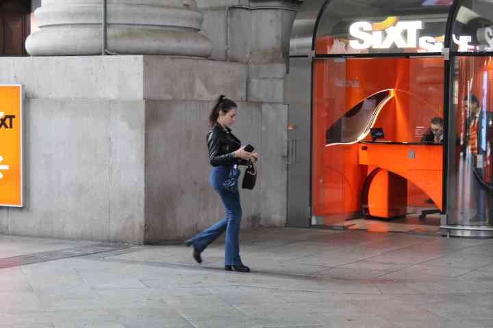 D'une femme  devant une agence de location de voitures Sixt photo gratuite