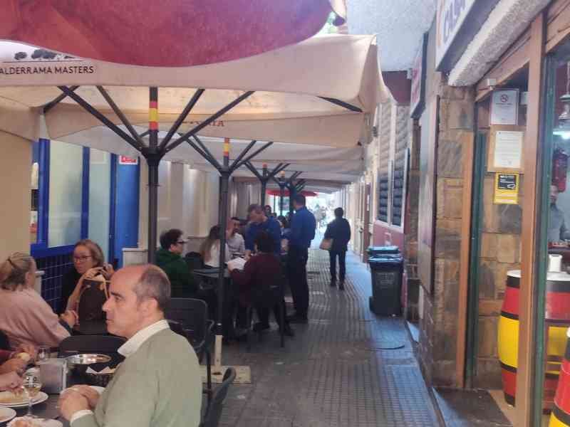Des personnes assises à des tables de restaurant sous des parasols, photo gratuite