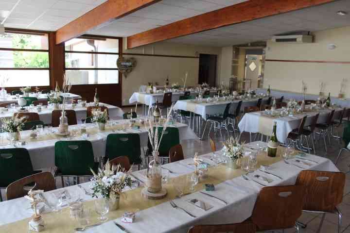 Une salle de réception décorée pour un événement, les tables sont dressées avec des nappes blanches et des bouteilles de vin, photo gratuite