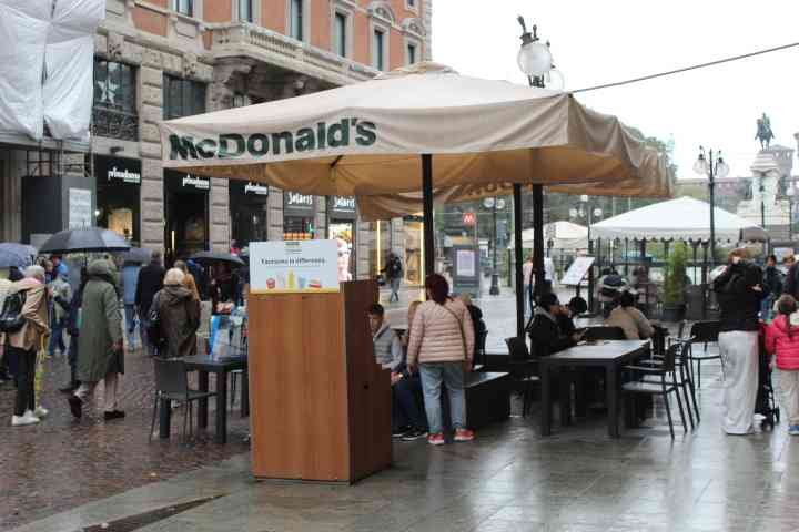 Des tables et des chaises installées sous le parasol, indiquant un espace de restauration McDonald's, un espace extérieur aménagé pour les clients, photo gratuite