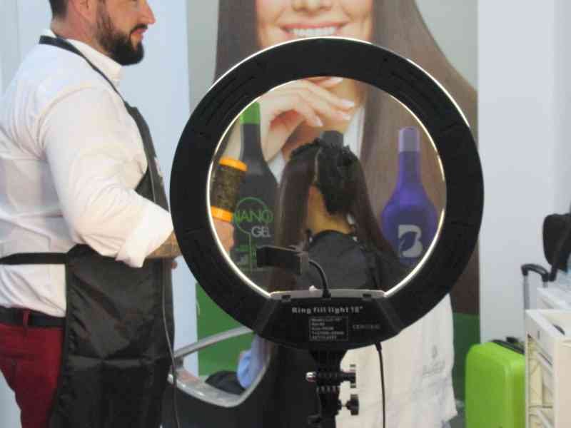 Ring light éclairant une femme dans un salon de beauté