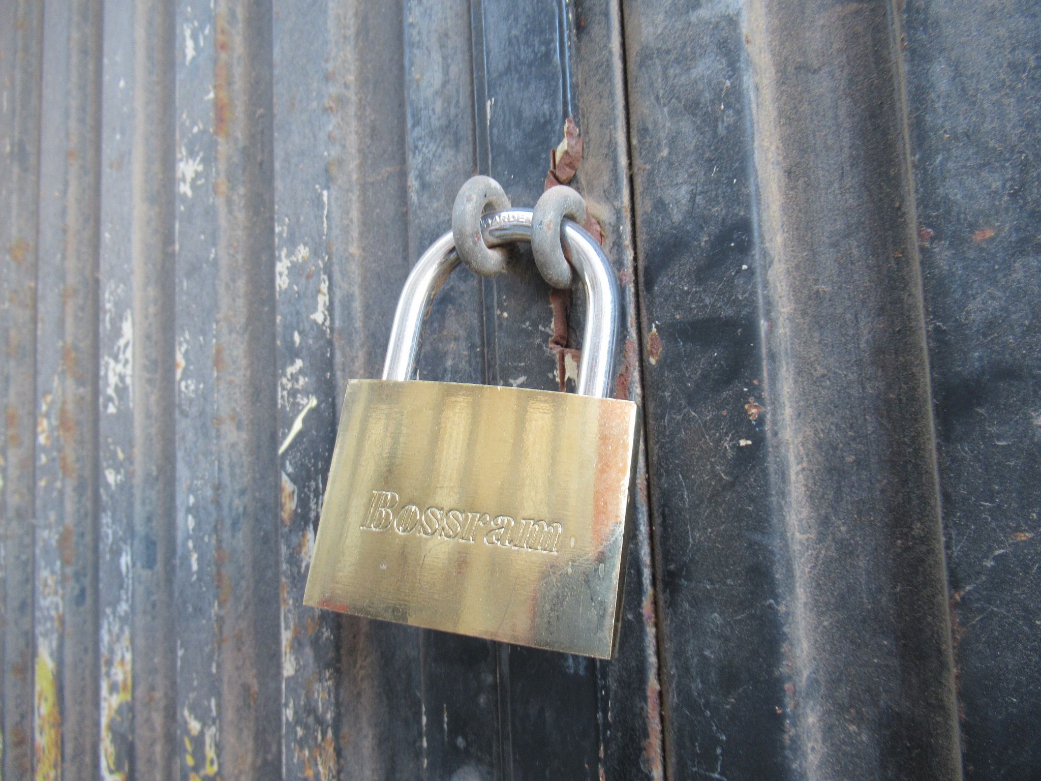 A locked Bossram padlock, attached to a container door, free photo
