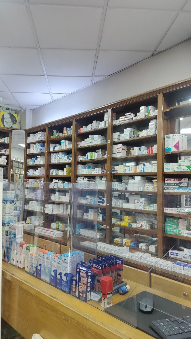 L'intérieur d'une pharmacie, avec des étagères en bois remplies de divers médicaments et produits de santé, photo gratuite